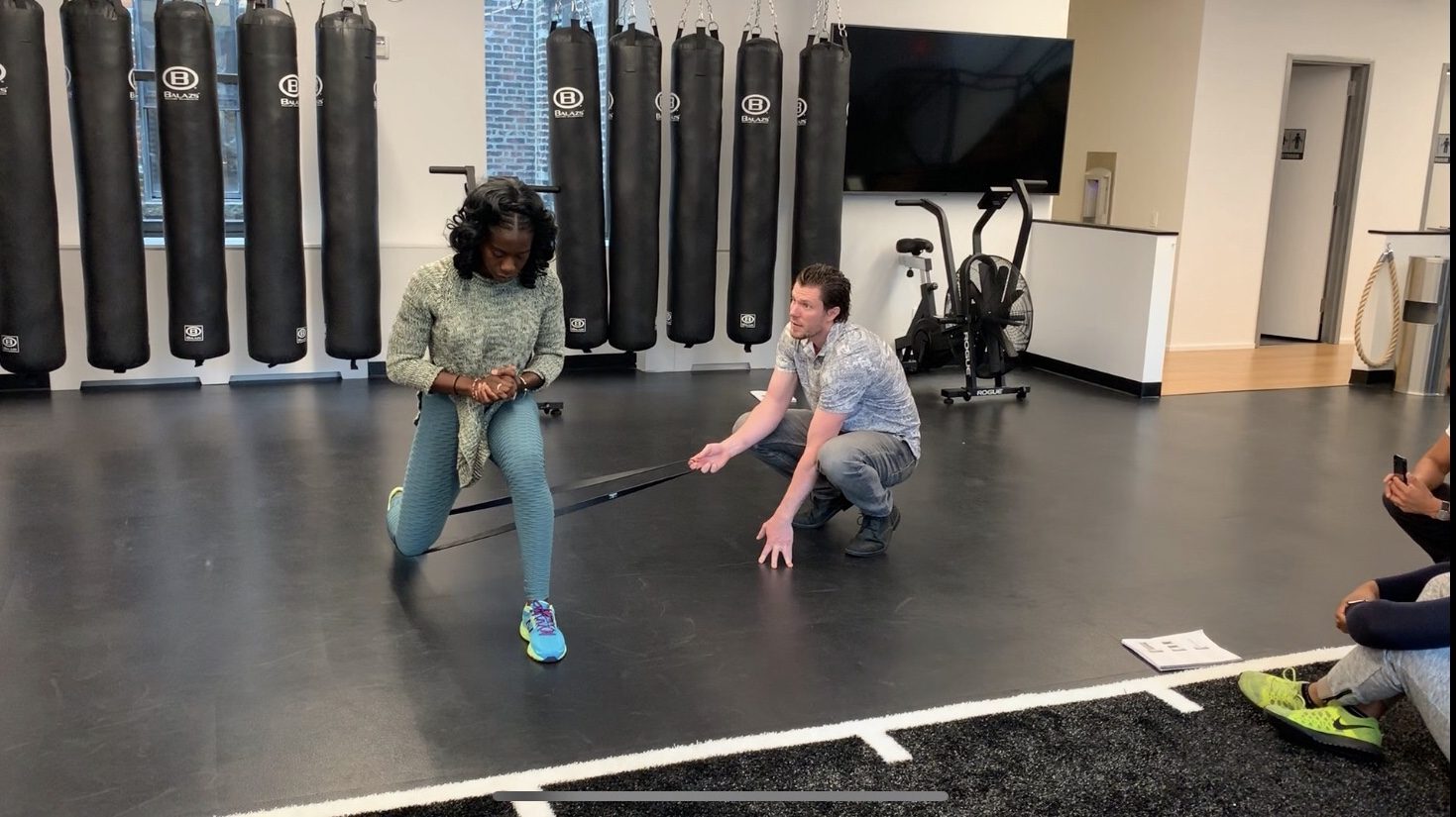 A coach guiding a resistance-band training session